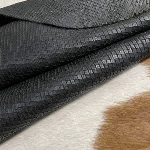 Introducing Alexa Veg Tanned Cow Leather - a special type of leather that is crafted from full grain hide and treated with vegetal tanning. This unique leather boasts a reptile scale-like appearance, but with a more polished and refined look. An aniline finish gives it a waxy, matte texture, while deep grooves outline each square, highlighting their appearance. The squares are also creased, adding texture and definition. The Alexa collection is perfect for various leather needs due to its subtle shine and remarkable design. This leather is made from heifer (double shoulder) and weighs 5/6 oz. (2.2 mm-2.4 mm). It is 100% veg-tanned and dyed through (drum dye). The leather is classified as full-grain with a medium pull-up, has a semi-soft temper, and is sourced from Mexico. The Alexa leather is perfect for crafting straps, handbags, accessories, footwear, belts, and leather crafts.