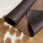 Introducing Alexa Veg Tanned Cow Leather - a special type of leather that is crafted from full grain hide and treated with vegetal tanning. This unique leather boasts a reptile scale-like appearance, but with a more polished and refined look. An aniline finish gives it a waxy, matte texture, while deep grooves outline each square, highlighting their appearance. The squares are also creased, adding texture and definition. The Alexa collection is perfect for various leather needs due to its subtle shine and remarkable design. This leather is made from heifer (double shoulder) and weighs 5/6 oz. (2.2 mm-2.4 mm). It is 100% veg-tanned and dyed through (drum dye). The leather is classified as full-grain with a medium pull-up, has a semi-soft temper, and is sourced from Mexico. The Alexa leather is perfect for crafting straps, handbags, accessories, footwear, belts, and leather crafts.