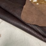 Introducing Alexa Veg Tanned Cow Leather - a special type of leather that is crafted from full grain hide and treated with vegetal tanning. This unique leather boasts a reptile scale-like appearance, but with a more polished and refined look. An aniline finish gives it a waxy, matte texture, while deep grooves outline each square, highlighting their appearance. The squares are also creased, adding texture and definition. The Alexa collection is perfect for various leather needs due to its subtle shine and remarkable design. This leather is made from heifer (double shoulder) and weighs 5/6 oz. (2.2 mm-2.4 mm). It is 100% veg-tanned and dyed through (drum dye). The leather is classified as full-grain with a medium pull-up, has a semi-soft temper, and is sourced from Mexico. The Alexa leather is perfect for crafting straps, handbags, accessories, footwear, belts, and leather crafts.