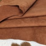 What is nubuck leather This material is suitable for footwear, accessories, handbags, apparel, craft, belts, and DIY projects. Nubuck leather is swine (pig leather) that has a medium soft temper and a chrome tannage. It has a texture that is referred to as nubuck and an average hide size of 8-10 sq. ft. The thickness is 3 oz. (1.0 – 1.2 mm). The raw material comes from the subspecies Sus scrofa domesticus and is from Taiwan. It can be used for DIY projects.