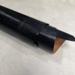 Lizard Black | Avetco Leather Hides and Eva Foam Lizard embossed cowhide black color rolled view. Lizard Embossed Cowhide is a vegetable-tanned leather with a bold, exotic texture. At 3 oz thick and medium temper, it’s ideal for bags, belts, wallets, and costume work. This high-quality cowhide is tanned in Mexico and embossed with a sharp, consistent lizard pattern.