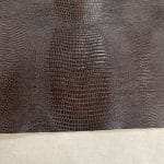 Close-up of lizard embossed cowhide texture in brown.Lizard Embossed Cowhide is a vegetable-tanned leather with a bold, exotic texture. At 3 oz thick and medium temper, it’s ideal for bags, belts, wallets, and costume work. This high-quality cowhide is tanned in Mexico and embossed with a sharp, consistent lizard pattern.
