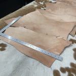 This is a 2LB full-grain tooling Cow leather made using a natural vegetable tanning process, which is perfect for small projects like jewelry making, altered art, wallets, portraits, clutches, holsters, knife sheaths, key fobs, and more. The leather is made from 100% cowhide and is tanned naturally, with a thickness ranging from 6 oz - 8 oz. The leather color is natural and will darken over time if left untreated or exposed to sunlight. It's important to note that the hide may have scratches, different tones, and various shades of natural leather color. It has a medium to stiff texture and comes in various sizes.