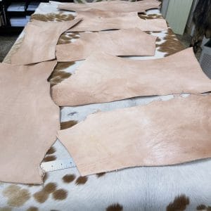 This is a 2LB full-grain tooling Cow leather made using a natural vegetable tanning process, which is perfect for small projects like jewelry making, altered art, wallets, portraits, clutches, holsters, knife sheaths, key fobs, and more. The leather is made from 100% cowhide and is tanned naturally, with a thickness ranging from 6 oz - 8 oz. The leather color is natural and will darken over time if left untreated or exposed to sunlight. It's important to note that the hide may have scratches, different tones, and various shades of natural leather color. It has a medium to stiff texture and comes in various sizes.