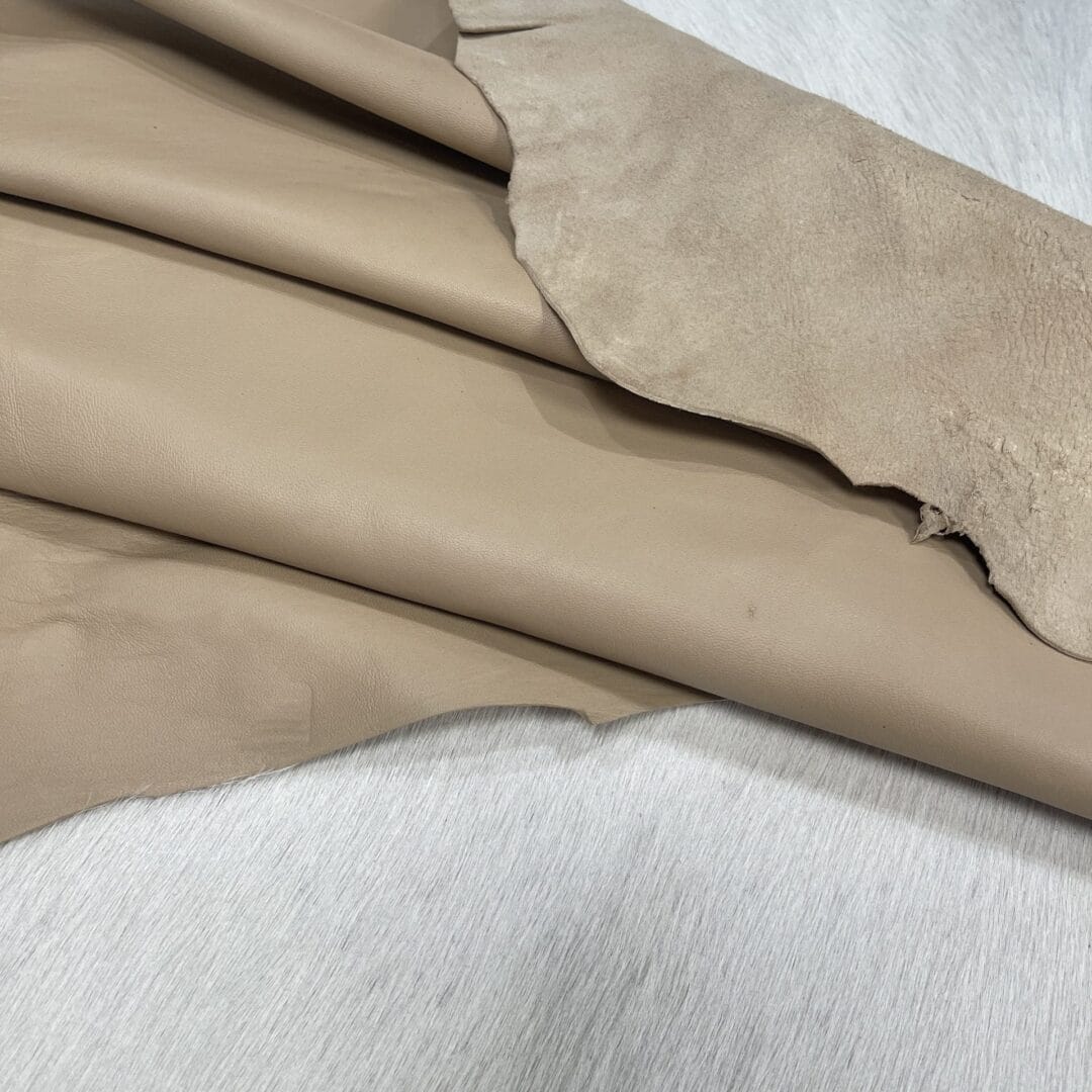 Lambskin Leather Grade C is a type of leather that might have some imperfections, but they do not affect its performance. Instead, these flaws give it a unique appearance. The leather's raw material is sourced from sheep or lamb, and it weighs 2 oz. with a thickness of 0.7-0.9 mm. Furthermore, the economy grade Lamb leather may have uneven shade tone, dark spots, stretch marks, scarring, scratches, or a few holes. However, these flaws do not affect its performance. Instead, they give it a unique appearance that sets it apart from other types of leather.