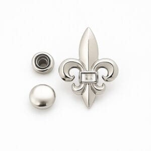 Nickel Fleur De Lis decorative rivet set with matching flat round cap and snap components arranged neatly on a clean white background.