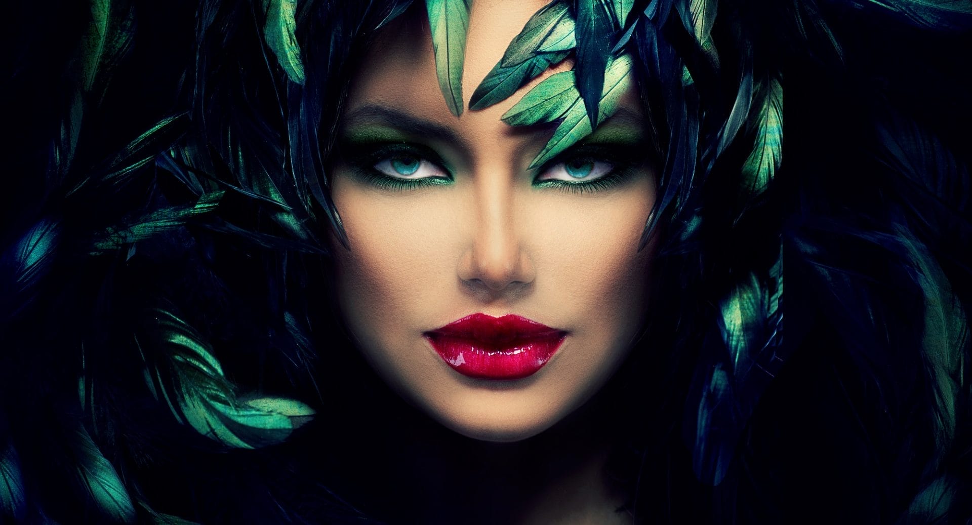 Fashion model with green feathered headdress, dramatic leather-inspired accessories