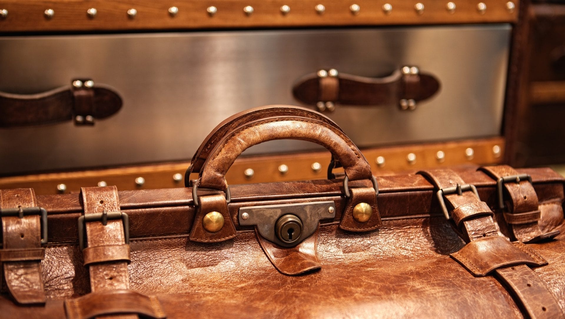 "Vintage brown leather suitcase handle detail for accessories inspiration."