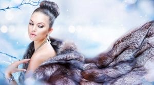 Elegant fashion model in fur coat with leather accents and jewelry accessories