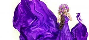 Fashion model in flowing purple gown accessorized with floral headdress