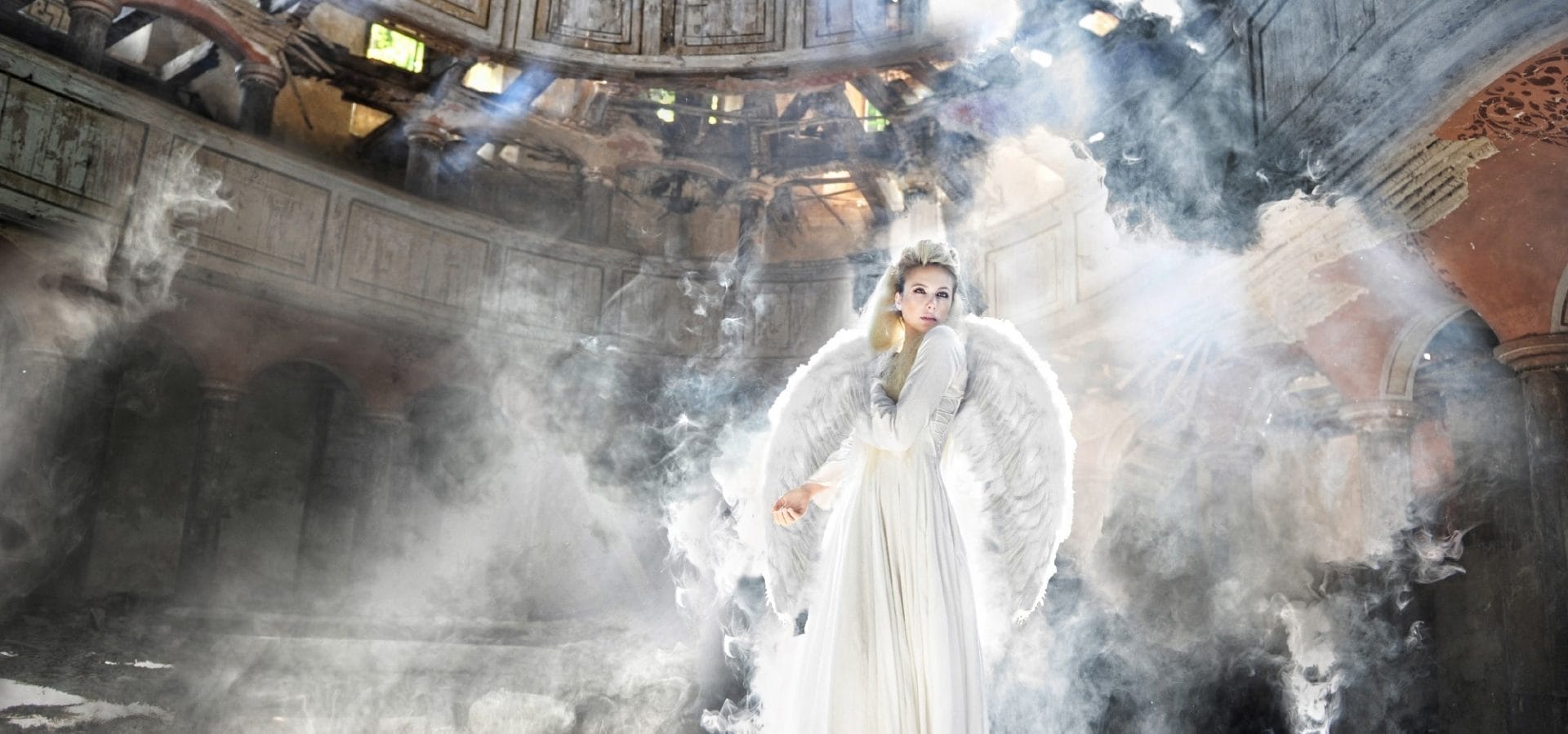 Fashion model dressed as ethereal angel with soft flowing leather-textured dress