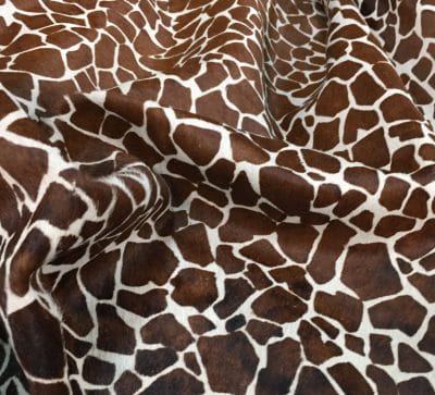 This chestnut cowhide features a bold giraffe print, offering a unique, exotic touch to any project. Perfect for handbags, upholstery, footwear, garments, pillows, and décor. Printed on premium hair-on cowhide for durability and natural texture with a wild, stylish edge. Each hide is one-of-a-kind—ideal for standout fashion and interior designs.