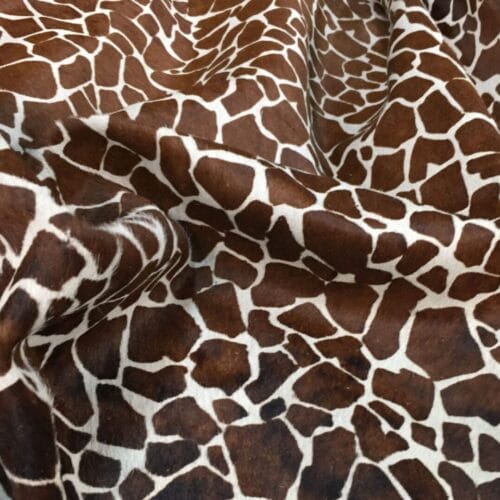 This chestnut cowhide features a bold giraffe print, offering a unique, exotic touch to any project. Perfect for handbags, upholstery, footwear, garments, pillows, and décor. Printed on premium hair-on cowhide for durability and natural texture with a wild, stylish edge. Each hide is one-of-a-kind—ideal for standout fashion and interior designs.
