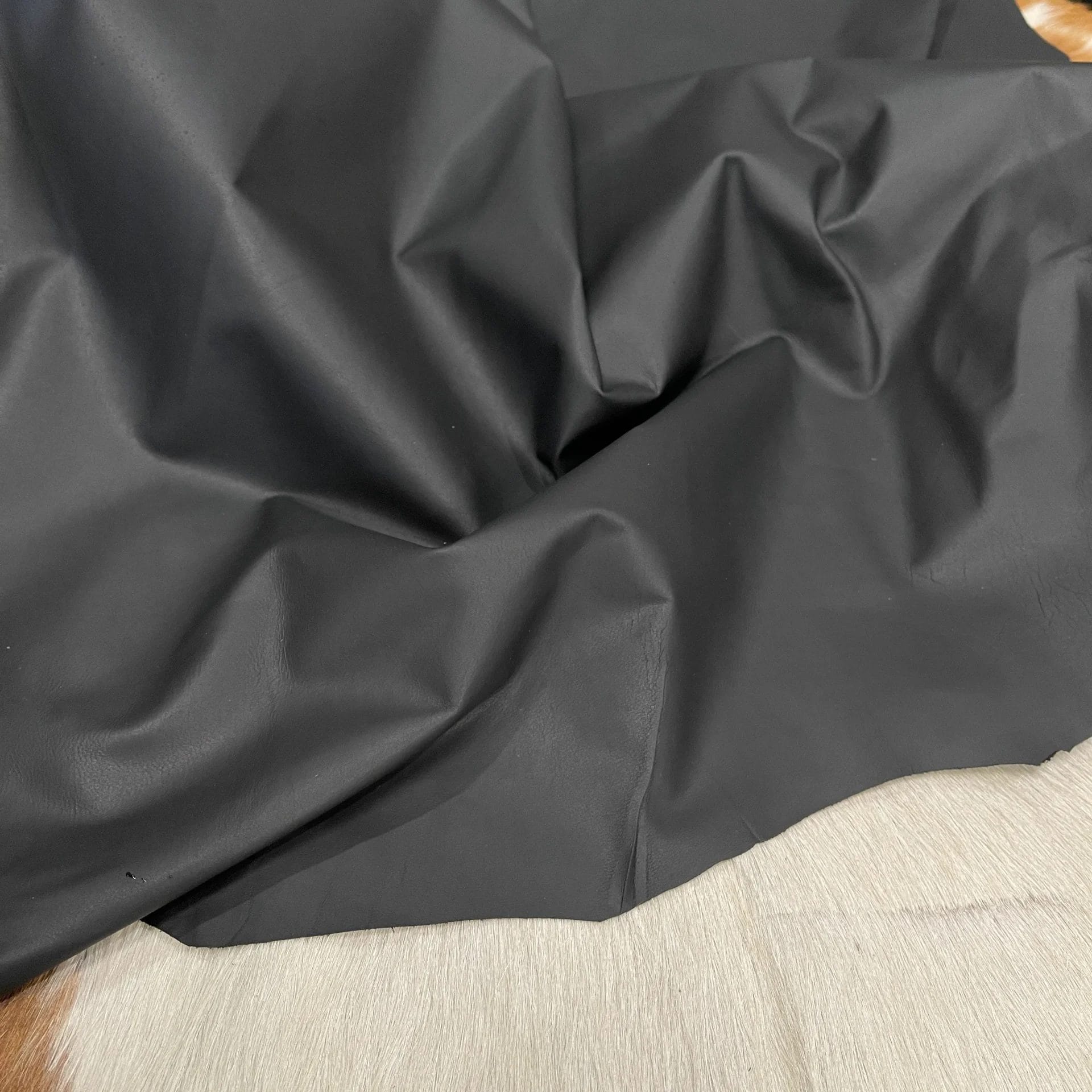 SL-100BLK Lambskin Leather Avetcoinc This high-quality lambskin garment leather is made from 100% British lambskin, renowned for its soft and supple texture. The leather is expertly tanned using the chrome tanning process, which results in a durable and long-lasting product that will wear beautifully over time. The leather is available in a full hide size of 5-7 sq. ft. and has a full-grain finish, which means that it retains the natural texture and markings of the original hide. The thickness of the leather is 1 oz, which equates to a range of 0.4-0.6 mm. The leather is sourced from Turkey, where it undergoes rigorous quality control procedures to ensure that it meets the highest standards. The resulting product is a premium-grade leather that is perfect for creating luxurious garments and accessories that will stand the test of time.