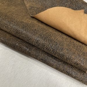 The Oklahoma collection leather is not just about its unique crackle finish and vintage look. It's also a testament to durability. Crafted from chrome-tanned heifer hide, it's been dyed-through to create a soft, suede base with a shiny wax transfer on top. This gives the leather a vintage, yet timeless look that's perfect for a variety of uses, including accessories like handbags, wallets, belts, and footwear. Its textured and strong appearance is a clear indication of its durability, making it an excellent choice for apparel and trim. The leather has an aniline finishing which gives it a rugged appearance. It is available in a weight of 3 oz. (1.2-1.4 mm) and has an average hide size of 22-25 Sq. Ft. It is tanned in Mexico and has a soft temper with a dull shine. We understand that the measurements of the leather can vary, and we want to assure you that your order is an estimate. The final cost will be determined once the hide is ready to ship. You will be refunded the difference if the leather is smaller than specified. This way, you can feel secure in your purchase and confident that you're getting the best value for your money.