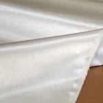 Bonded polyester satin with tricot backing, 58" wide, 0.3 mm thick. Available in Black, Champagne, Rose, Beige Copper, Bronze Red & Silver.
