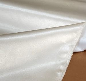 Bonded polyester satin with tricot backing, 58" wide, 0.3 mm thick. Available in Black, Champagne, Rose, Beige Copper, Bronze Red & Silver.