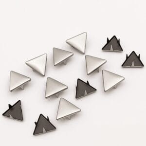 Detailed view of 10mm triangle nailheads in Nickel finish with black prongs, arranged in a scattered layout on white background – Avetco.