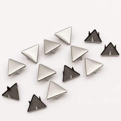 Detailed view of 10mm triangle nailheads in Nickel finish with black prongs, arranged in a scattered layout on white background – Avetco.