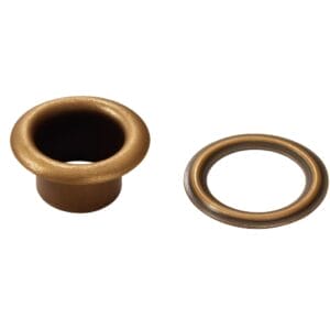 Beveled grommet and washer set in antique brass finish on white background.-Avetco