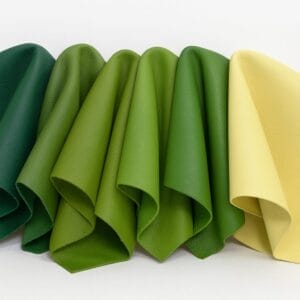 Lamb leather swatches in various green and yellow shades arranged side by side.-Avetco