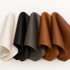 Neutral and earthy toned lamb leather swatches including white, black, gray, cognac, and rustic brown.-Avetco