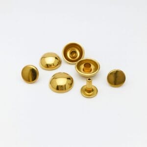 Polished gold dome rivets arranged on a clean white background, showing caps, sockets, and post details with a reflective metallic finish.