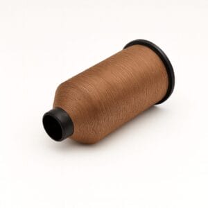 Spool of camel-colored nylon sewing thread on a white background – Avetco