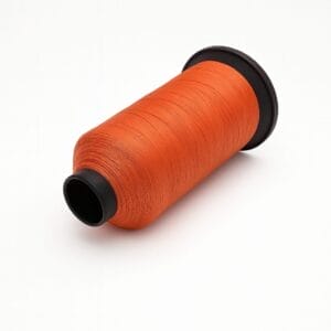 Bright orange nylon thread spool on white background – Avetco
