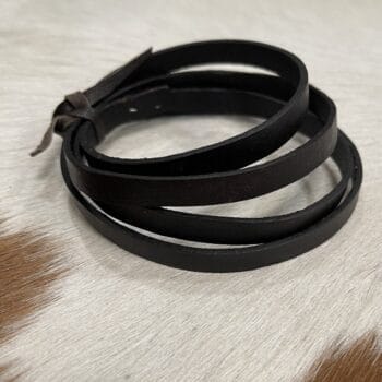 Black leather wrap bracelet with multiple slim bands coiled together on a light fur surface.